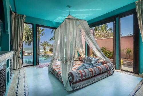 a swinging bed in a room with windows at Villa Maroc Resort in Pran Buri
