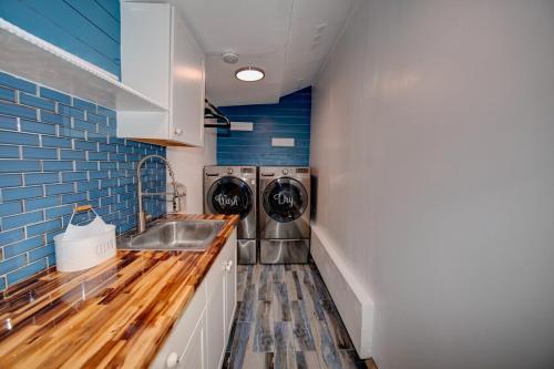 a kitchen with a sink and a washing machine at Margarita-Ville on the water! Stunning Sunsets!! in Jensen Beach