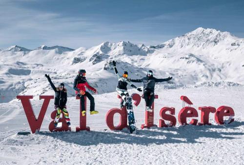 Un groupe de personnes debout à côté d'un panneau dans la neige dans l'établissement Résidence Les Crêts 1 - Val-d'Isère, à Val dʼIsère