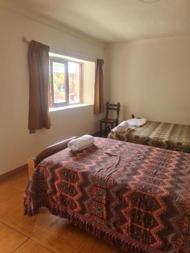 a bedroom with two beds and a window at Casa Conquista in Cusco