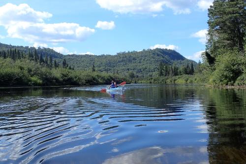 a couple of people riding a kayak on a river at Domaine le Bostonnais - Le Village en Bois Rond in La Tuque