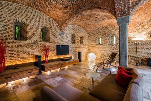 a living room with a couch and a tv in a brick wall at Indrani Lodge in Loupoigne