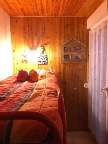 un lit dans une chambre avec un mur en bois dans l'établissement Appartement accueillant avec vue montagne, 25 m², à Eyne