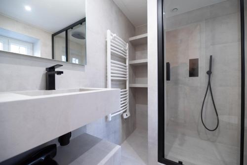 une salle de bain avec un lavabo et une douche dans l'établissement CIA - Home on Grands Boulevards, à Paris