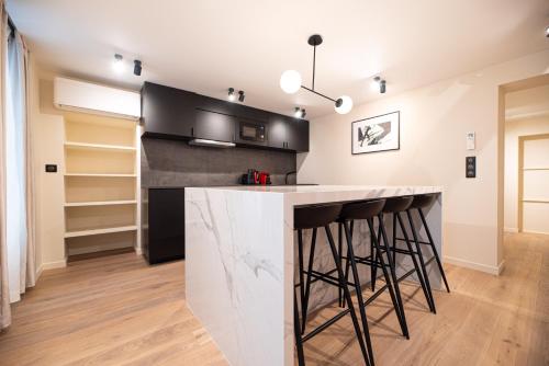une cuisine avec un comptoir et des tabourets de bar dans l'établissement CIA - Home on Grands Boulevards, à Paris