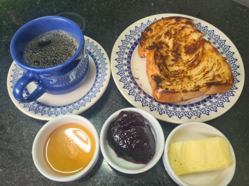 un tavolo con piatti di cibo e una tazza di caffè di Casa Azul - Quitandinha a Petrópolis