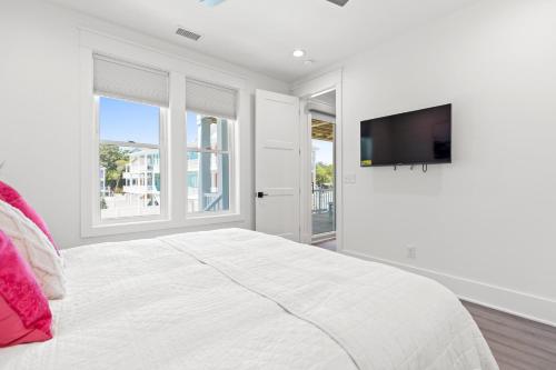 ein weißes Schlafzimmer mit einem großen Bett und einem Flachbild-TV in der Unterkunft NEW Orchards Ocean in Oak Island, Custom home with private heated pool in Oak Island