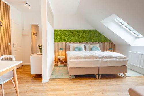 a bedroom with a bed with a green accent wall at Ferienhof Taarstedt Mikkey in Taarstedt