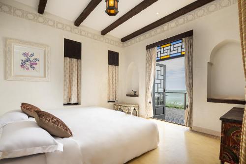 a bedroom with a large bed and a large window at Villa Maroc Resort in Pran Buri
