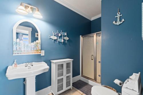 a blue bathroom with a sink and a shower at Experience luxury at On The Rocks, spacious 4 bedroom retreat with private pool! in Ocean Isle Beach