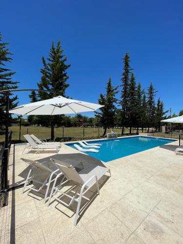 two chairs and an umbrella next to a swimming pool at Anna Apart Boutique in Colón