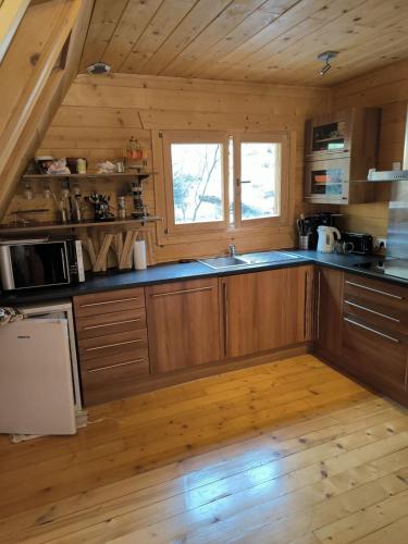 Il comprend une cuisine avec des placards en bois et du parquet. dans l'établissement Merveilleux chalet à la montagne, à La Colmiane