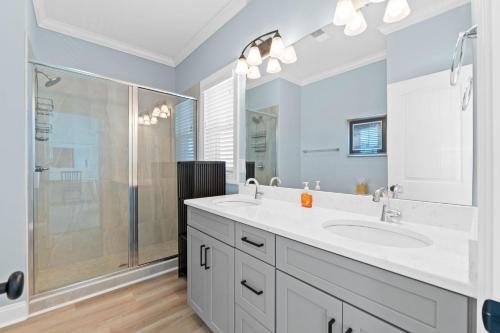 a white bathroom with a sink and a shower at Experience luxury at Notorious OIB, a spacious 4 bedrooms, 4 baths, perfect for up to 10 guests in Ocean Isle Beach