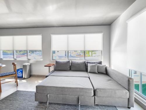 a bedroom with a large bed and windows at Aquabella 7 Paradise Stay in Isla Verde in San Juan