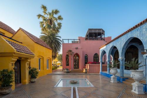 a courtyard of colorful buildings with a fountain in the middle at Villa Maroc Resort in Pran Buri
