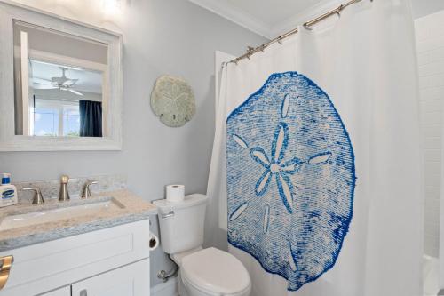 a bathroom with a surfboard on the shower curtain at Coastal Sunset - private heated pool, spa, close walk to the beach in Ocean Isle Beach