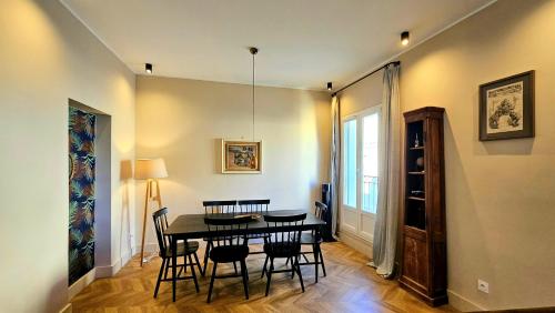 une salle à manger avec une table et des chaises noires dans l'établissement Beautiful apartment center of Montpellier, à Montpellier