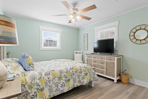 a bedroom with a bed and a flat screen tv at Remodeled Beach Happy 4 Bedroom 2 Bathroom for 9 Guests! in Ocean Isle Beach