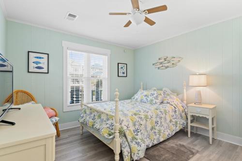a bedroom with a bed and a ceiling fan at Remodeled Beach Happy 4 Bedroom 2 Bathroom for 9 Guests! in Ocean Isle Beach