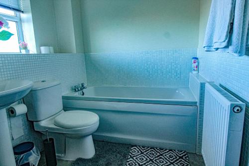 Un baño con inodoro, bañera y lavabo. en Ripley House by Smart Corporate Stays, en Ripley