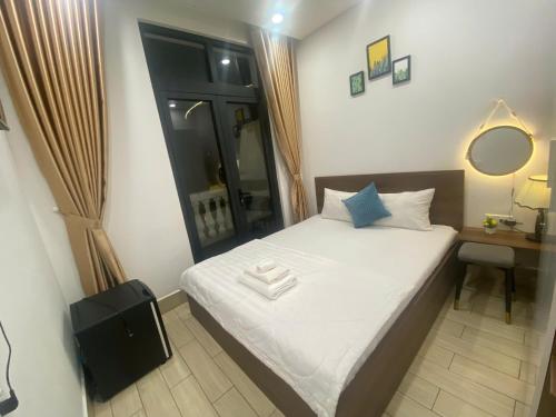 a small bedroom with a bed and a desk with a mirror at B&K Homestay - Glocery Store in Phu Quoc