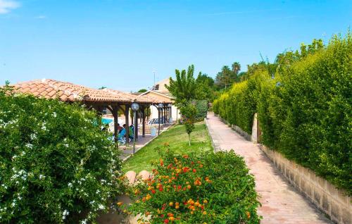 a garden with flowers and trees and a building at Awesome Apartment In Isola Capo Rizzuto in Isola Capo Rizzuto
