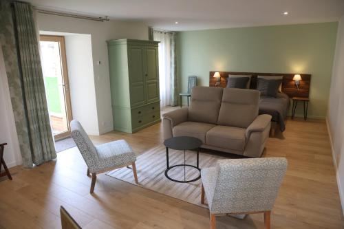 a living room with a bed and a couch and chairs at Le manse des janades in Rosières