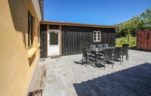 a patio with a table and chairs and a building at 3 Bedroom Amazing Home In Samsø in Sælvig
