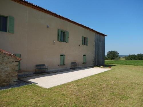 a building with two chairs in front of it at Le manse des janades in Rosières