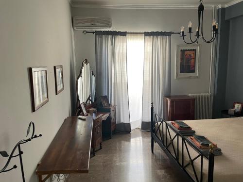 a bedroom with a bed and a table and a mirror at Luxury-Elegant apartment in the heart of Patras​ in Patra