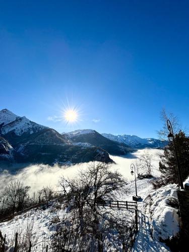 - une vue sur une montagne enneigée avec le soleil en arrière-plan dans l'établissement Gite L'emparis à 10 minutes des Deux-Alpes, à Mizoën