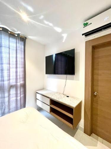 a bedroom with a bed and a tv on the wall at Novapark Kennedy Hotel in Guayaquil