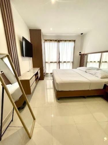 a bedroom with a bed and a desk with a television at Novapark Kennedy Hotel in Guayaquil