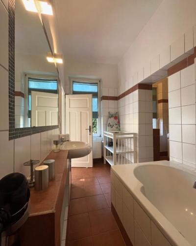 a large bathroom with a tub and a sink at Ferienwohnung Schönwälder mit kleiner Terrasse und WALL BOX in Buxtehude