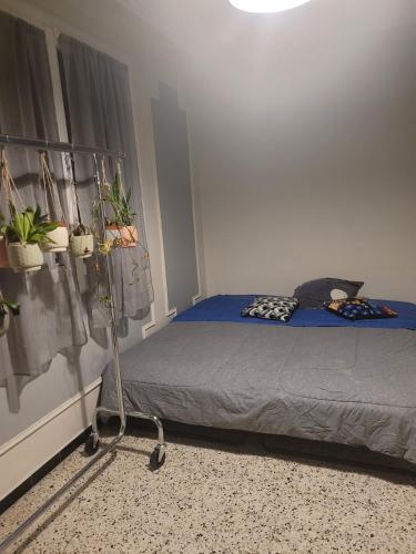 - une chambre avec un lit et des plantes sur le mur dans l'établissement Confortable appartement 2 chambres au centre d'Alès, à Alès