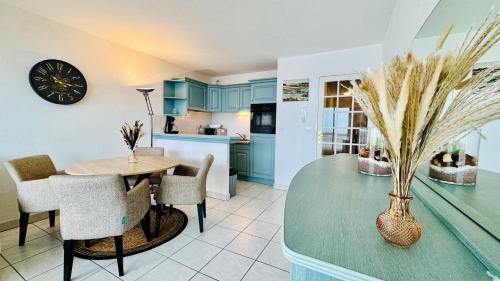 une cuisine et une salle à manger avec une table et des chaises dans l'établissement La longue vue - Face mer - Merlimont Plage, à Merlimont