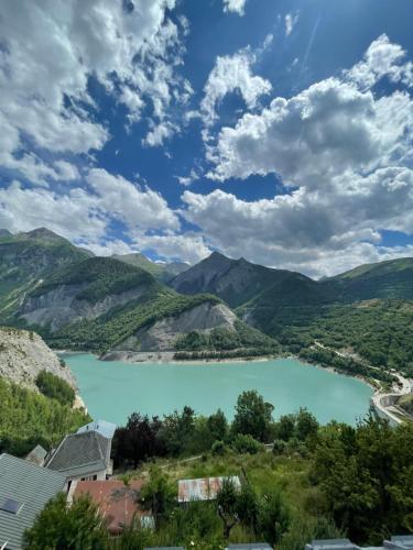 - une vue sur un lac bleu dans les montagnes dans l'établissement Gite L'emparis à 10 minutes des Deux-Alpes, à Mizoën