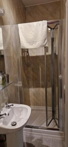 a bathroom with a sink and a shower with a towel at The Dudley Hotel in Blackpool