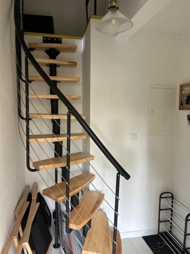 a wooden spiral staircase in a room with a lamp at Domek Marzenie in Radawa