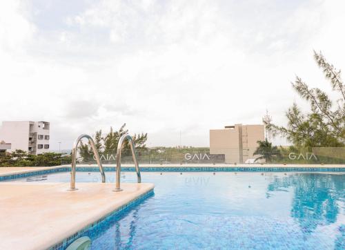 a swimming pool at a resort with buildings in the background at Gaia, Retreat Close to the Sea in Puerto Morelos in Puerto Morelos
