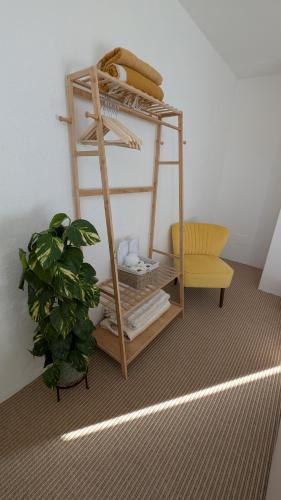 a room with a shelf with a plant and a chair at La Casa Della Seta in Mezzegra