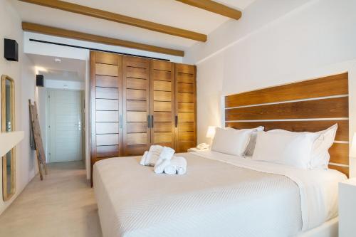 two beds in a bedroom with white sheets and towels at Apeiron Blue Santorini - Sustainable Adults Only 14 Plus in Fira