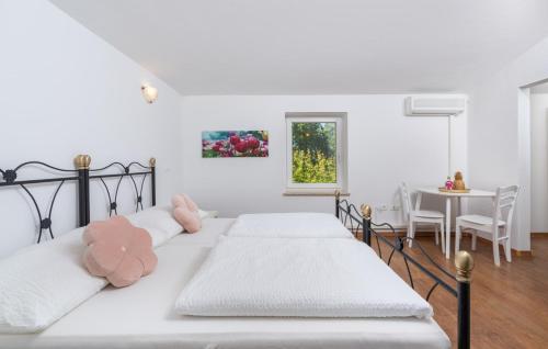 a bedroom with two white beds and a table at Villa Mali Raj in Žikovići
