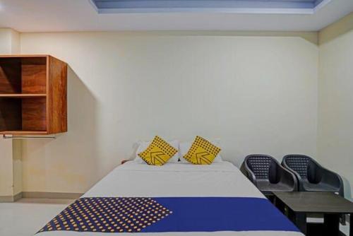 1 dormitorio con 1 cama con 2 sillas y armario en Saidham Comfort, en Bangalore