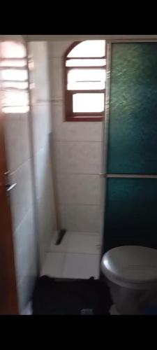 a small bathroom with a toilet and a window at Casa de praia Mongaguá in Mongaguá