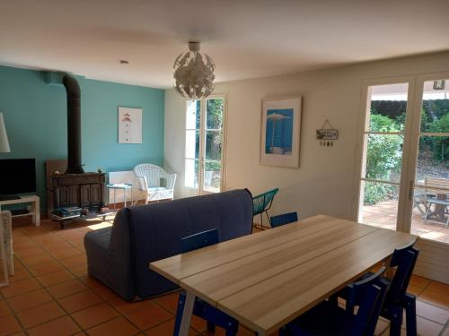 un salon avec une table en bois et un canapé dans l'établissement Maison avec terrasse à Vert Bois, à Dolus-d'Oléron