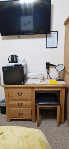 a wooden desk with a tv on top of it at The Dudley Hotel in Blackpool