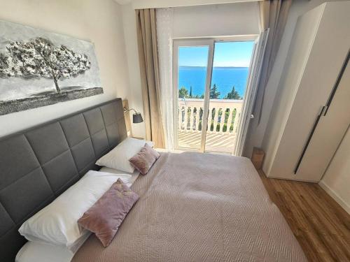 una camera da letto con un letto con vista sull'oceano di Apartments Amari a Starigrad-Paklenica (Ortopula)