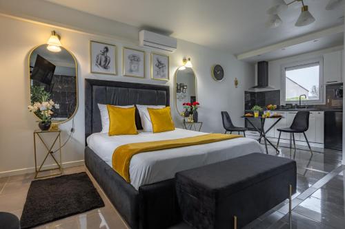 une chambre avec un grand lit avec des oreillers jaunes dans l'établissement Evasion romantique avec jacuzzi, à Savigny-le-Temple