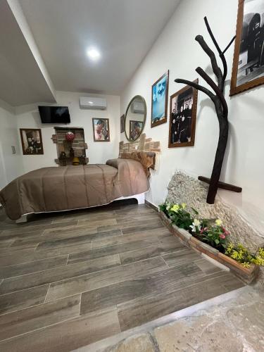 a bedroom with a bed and a tree on the wall at Dimora Forgione B&B - Pietrelcina in Pietrelcina